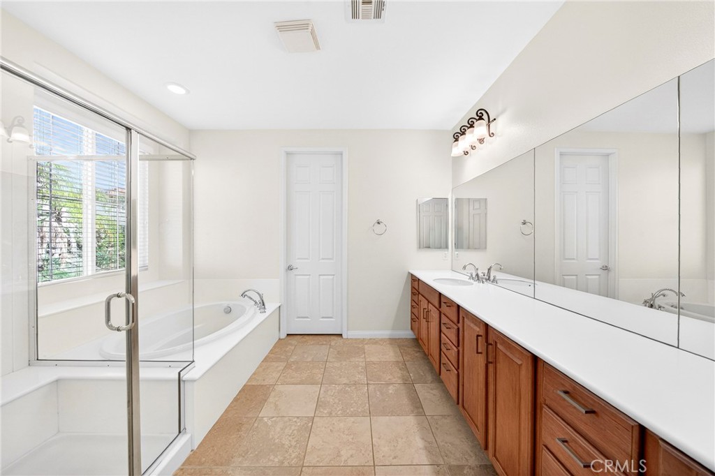 13740 Santa Maria Drive Rancho Cucamonga, CA 91739 - Photo 35 of 53 a spacious bathroom with a double vanity sink a mirror and a bathtub