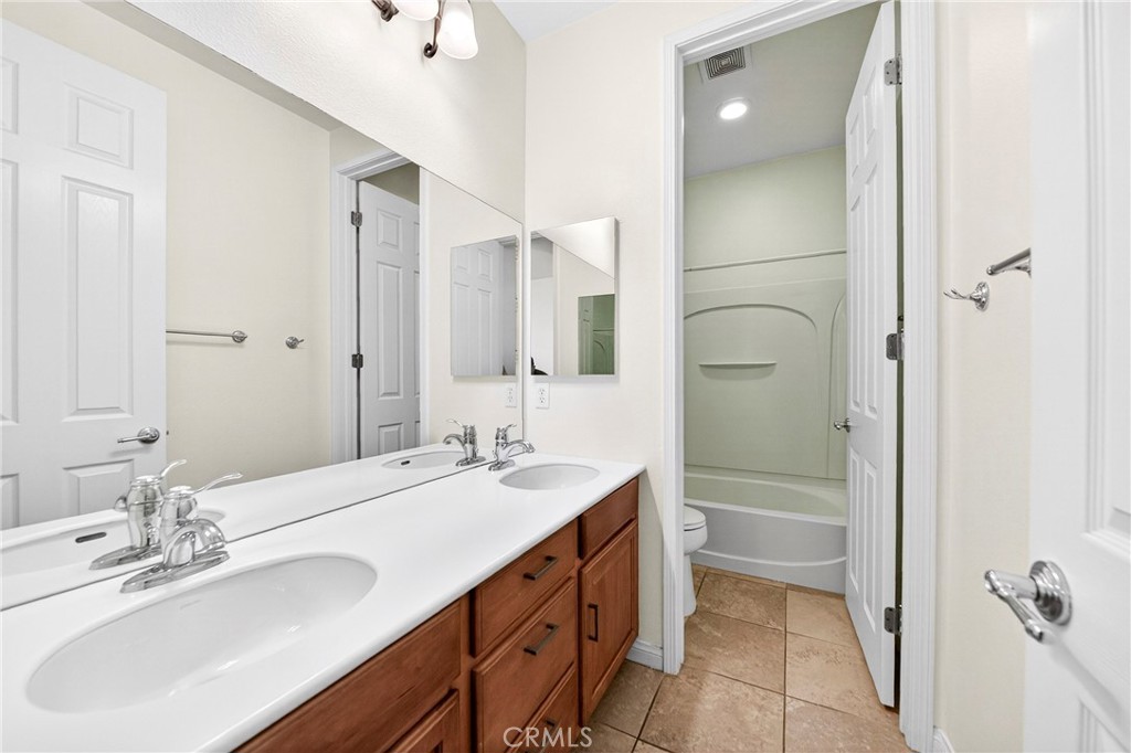 13740 Santa Maria Drive Rancho Cucamonga, CA 91739 - Photo 44 of 53 a bathroom with a double vanity sink a mirror and a shower