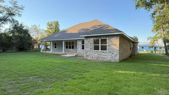 an empty room with wooden floor chandelier fan and windows