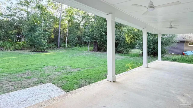 a view of a hallway with wooden floor and a ceiling fan