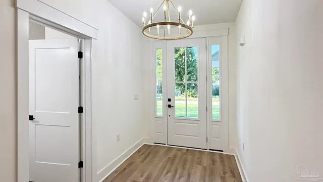 a kitchen with stainless steel appliances kitchen island granite countertop a sink a stove and a wooden floors