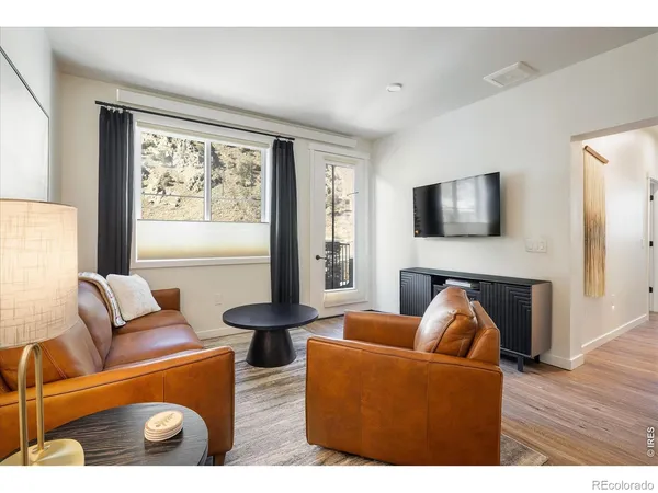 a living room with furniture a large window and a flat screen tv