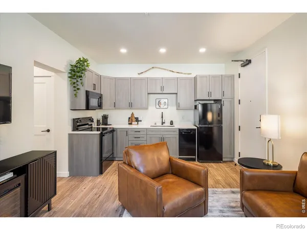 a kitchen with stainless steel appliances kitchen island granite countertop a refrigerator and a stove top oven