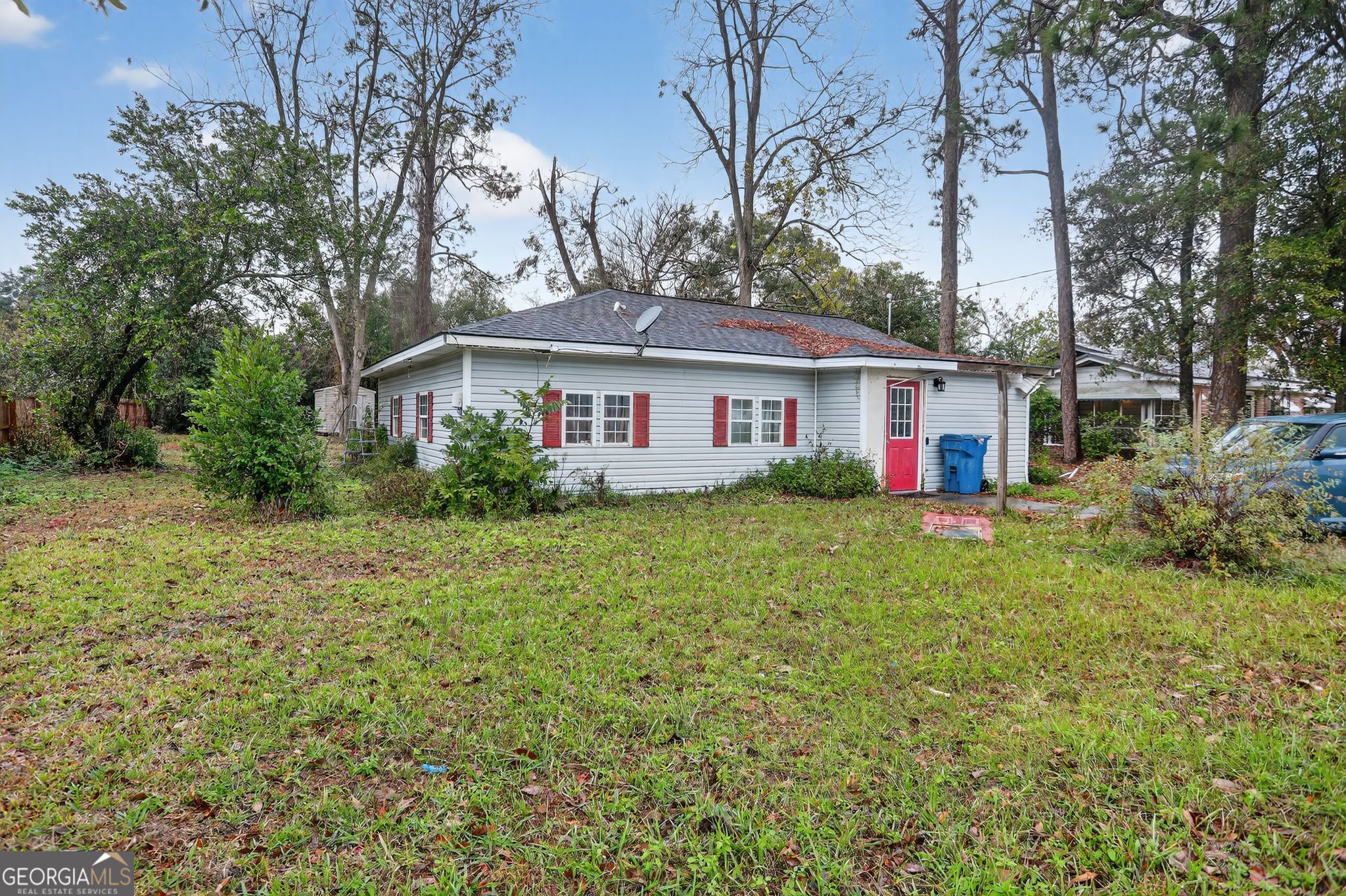 a front view of a house with a garden and trees