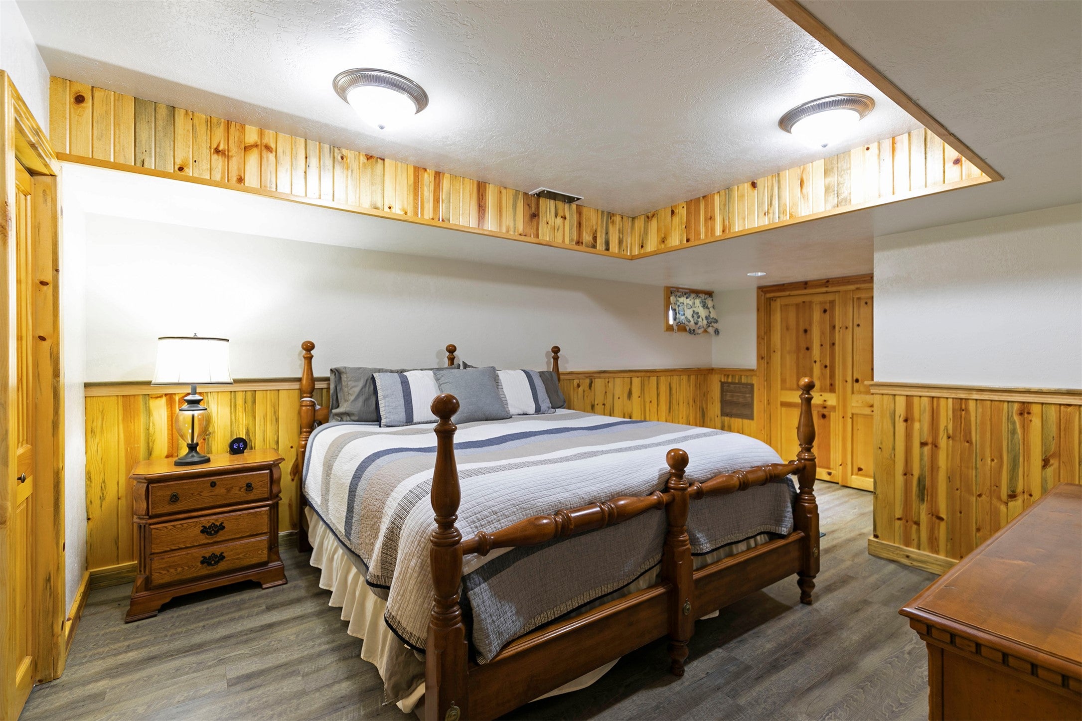 203 Hart Bench Road Darby, MT 59829 - Photo 26 of 56 The larger of the two basement bedrooms showcases elegant wood wainscoting, beautifully echoed in the tray ceiling trim, creating a warm and inviting retreat.