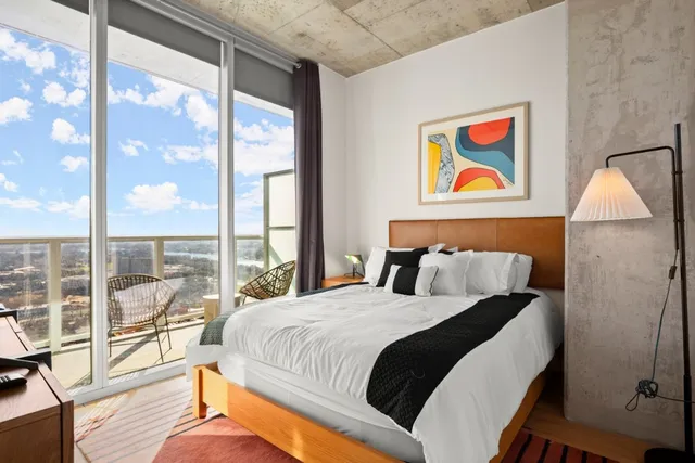 a bedroom with a bed and a large window with outer view