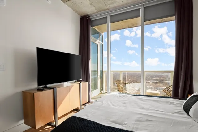 a living room with large window and a flat screen tv