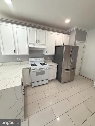 a kitchen with cabinets a refrigerator and a stove top oven