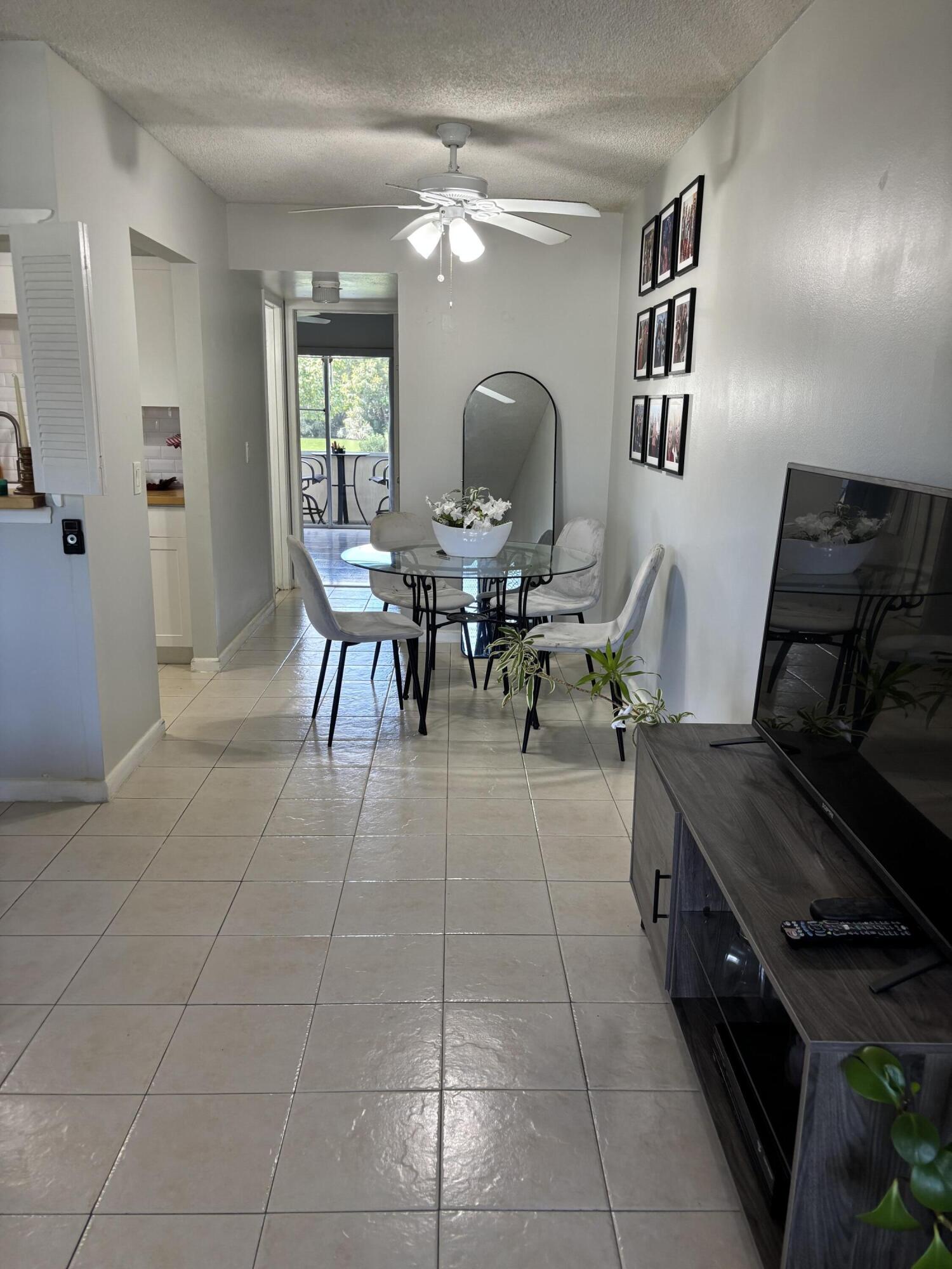 243 Northampton M, Unit 243 West Palm Beach, FL 33417 - Photo 12 of 15 a living room with patio furniture and a dining table