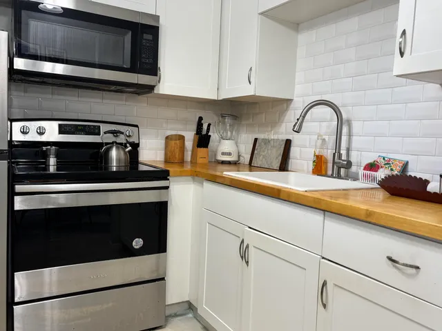 a kitchen with stainless steel appliances granite countertop a sink stove and microwave
