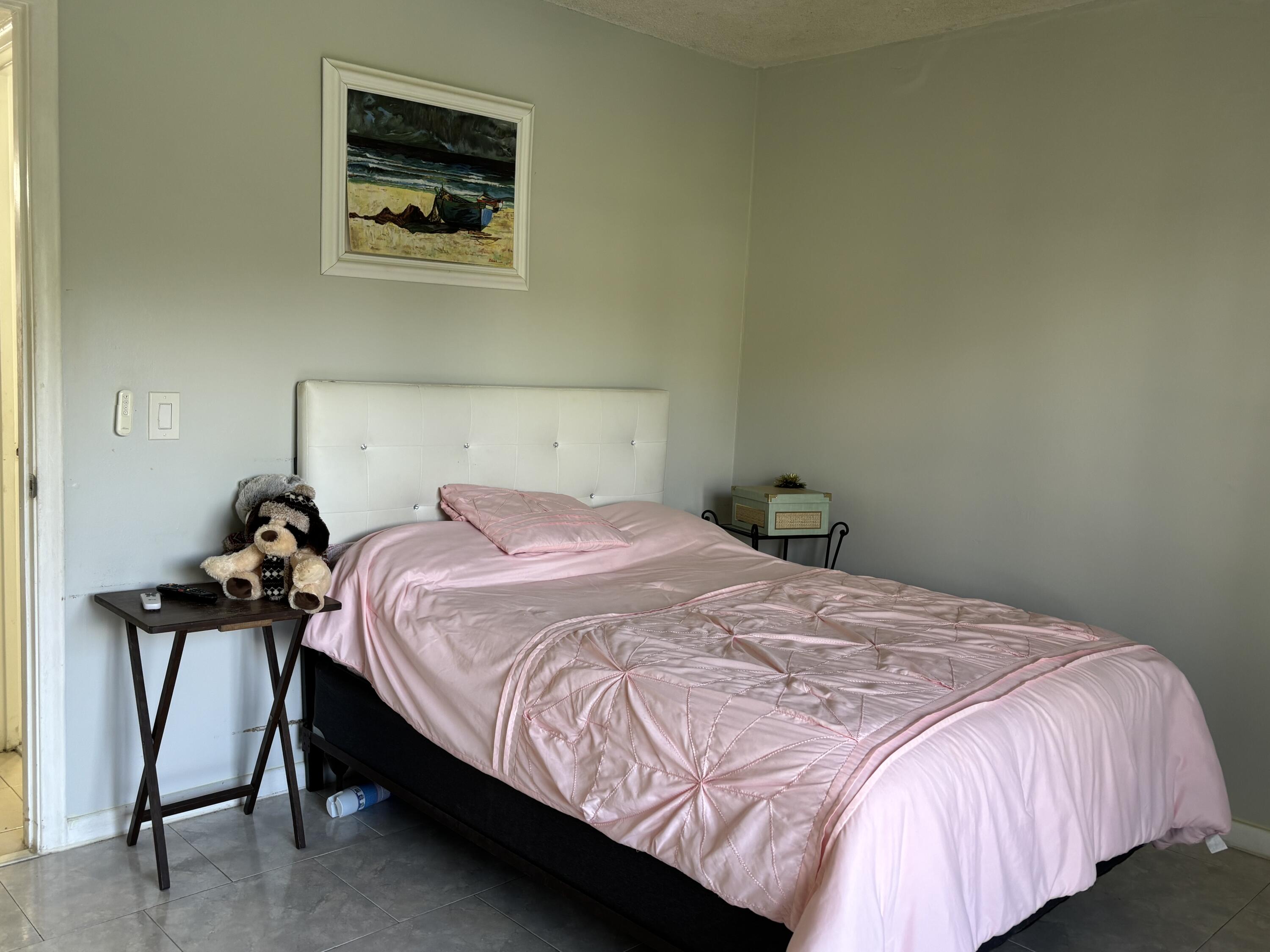 243 Northampton M, Unit 243 West Palm Beach, FL 33417 - Photo 5 of 15 a bedroom with a bed and painting on the wall