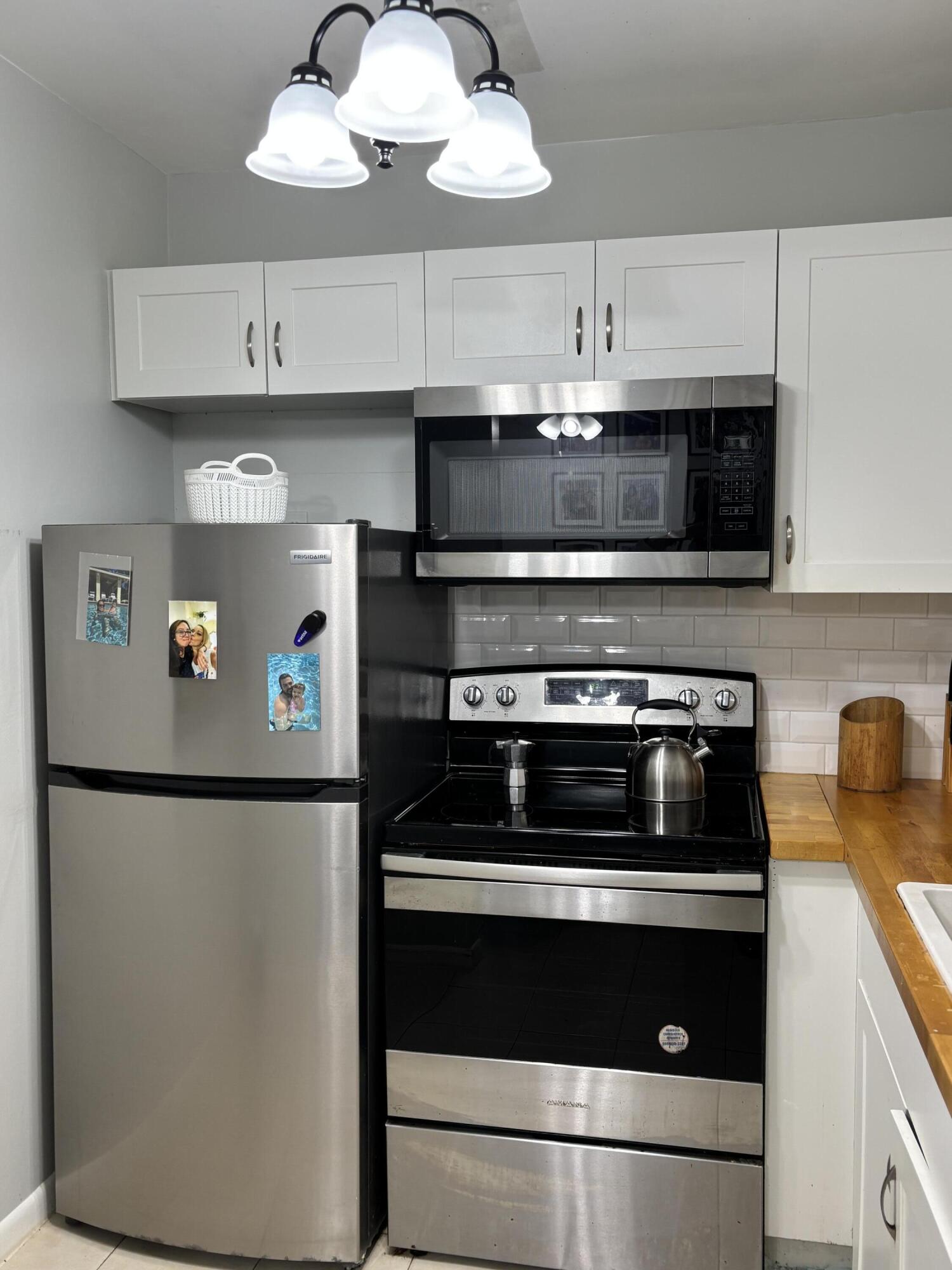 243 Northampton M, Unit 243 West Palm Beach, FL 33417 - Photo 7 of 15 a kitchen with stainless steel appliances granite countertop a refrigerator and a stove