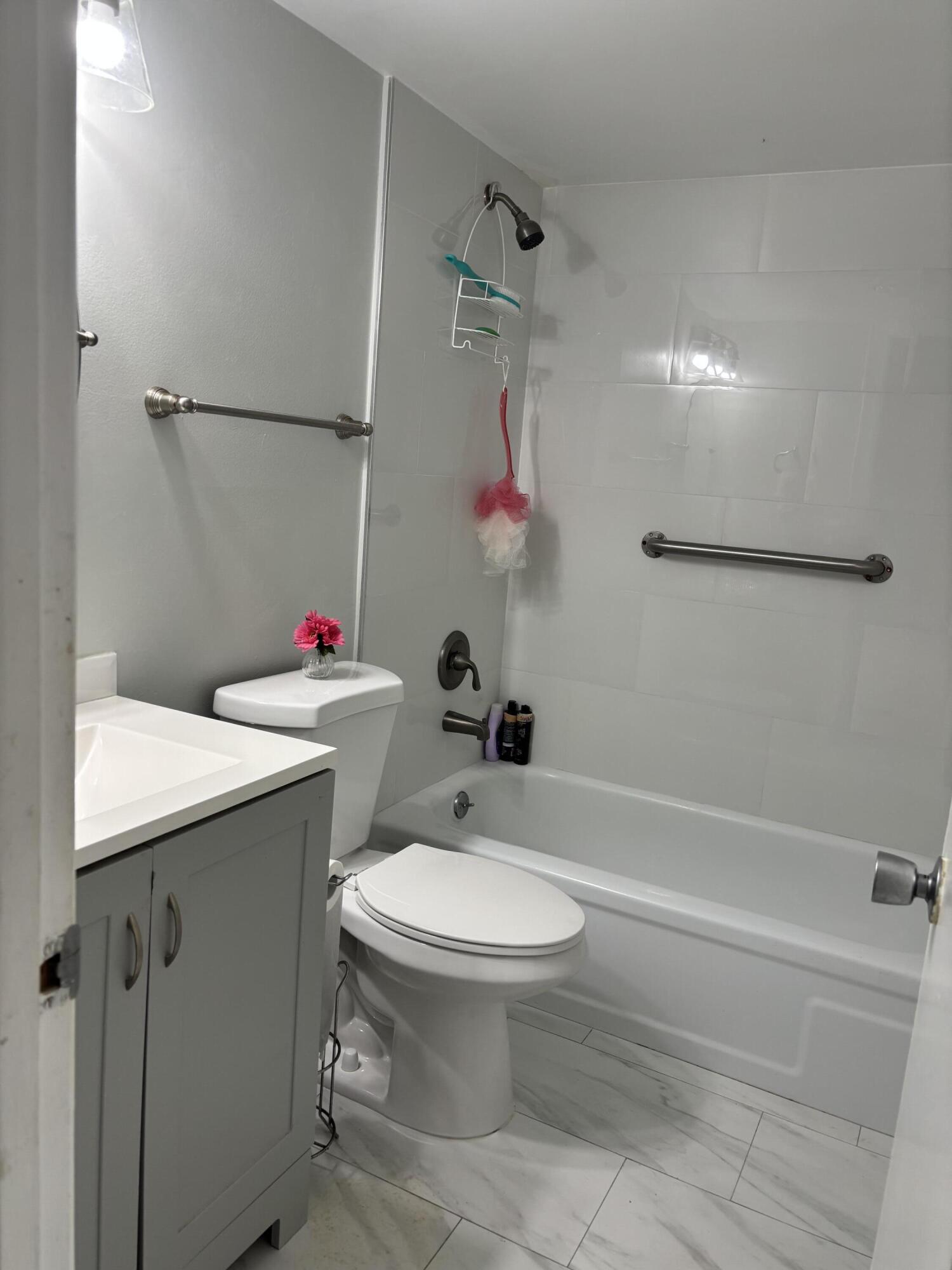 243 Northampton M, Unit 243 West Palm Beach, FL 33417 - Photo 10 of 15 a bathroom with a sink toilet and shower