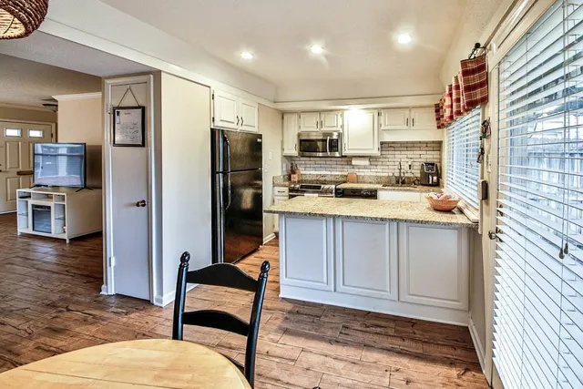 a kitchen with stainless steel appliances granite countertop a stove a sink and a microwave