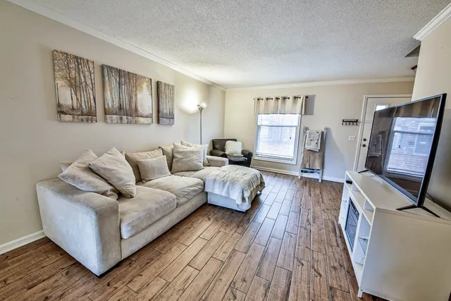 a bedroom with a bed wooden floor and lamp