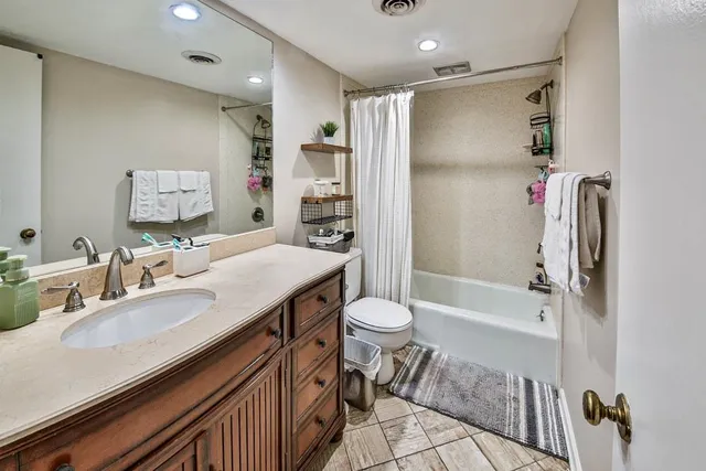 a bathroom with a granite countertop sink toilet and shower