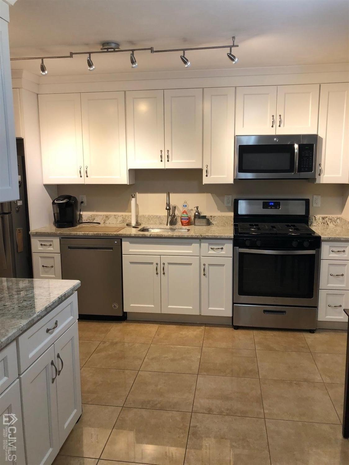 880 Robin Road Hillsborough, NJ 08844 - Photo 4 of 37 a kitchen with a stove top oven sink and cabinets