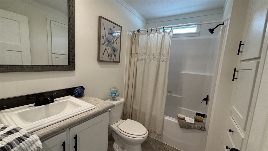 6 Berry Farms Road, Unit 6 Sturbridge, MA 01566 - Photo 11 of 16 a bathroom with a sink a toilet and shower curtain
