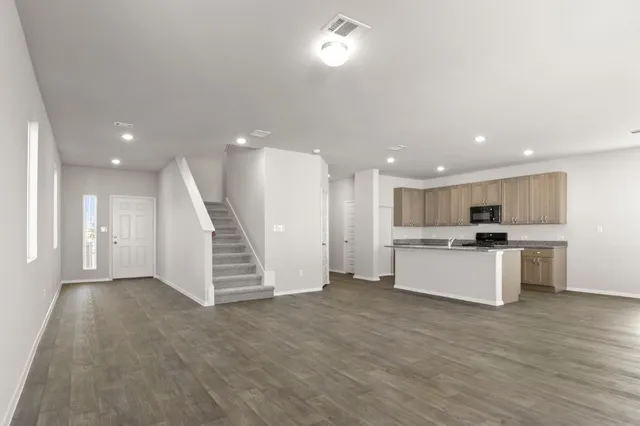 a kitchen with a refrigerator and white cabinets