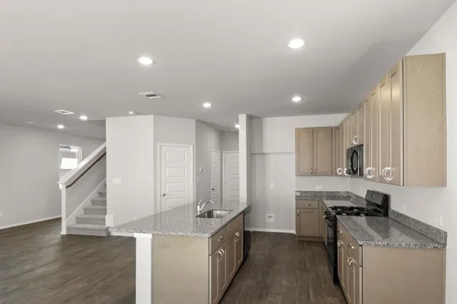 a kitchen with kitchen island a sink stainless steel appliances and cabinets
