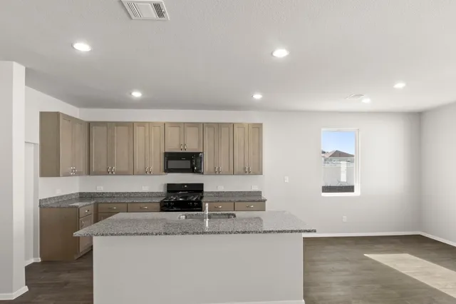 a kitchen with granite countertop white cabinets and stainless steel appliances