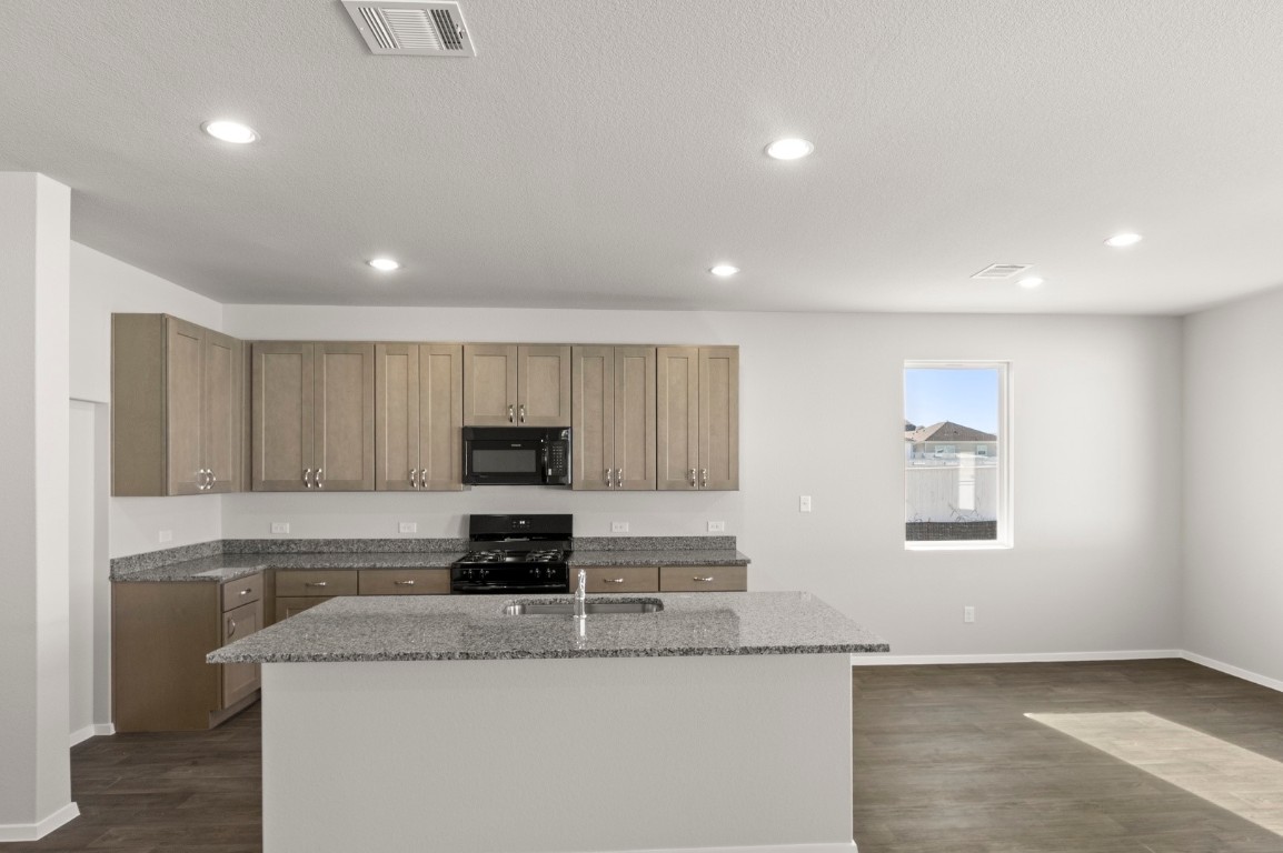 230 Barley Lane Elgin, TX 78621 - Photo 23 of 39 a kitchen with granite countertop a sink stove and cabinets