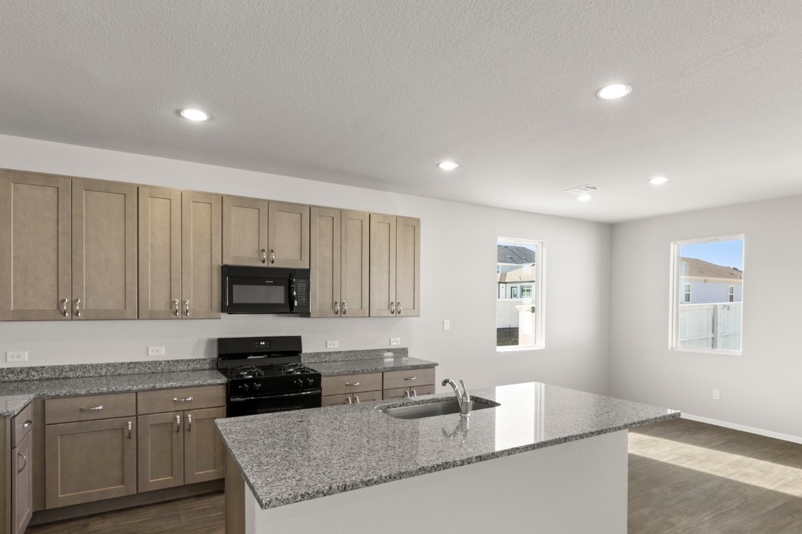 230 Barley Lane Elgin, TX 78621 - Photo 24 of 39 a kitchen with granite countertop white cabinets and stainless steel appliances