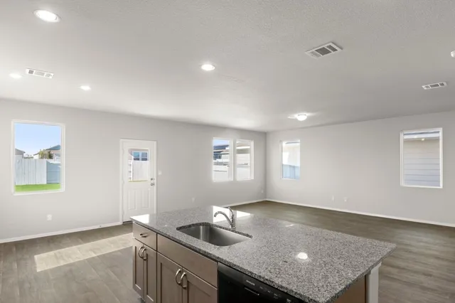 a kitchen with stainless steel appliances granite countertop a stove a sink and a refrigerator