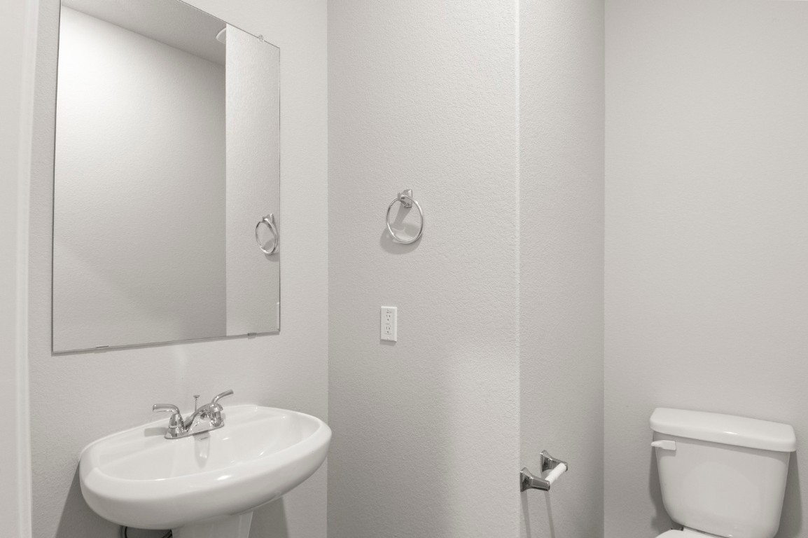 230 Barley Lane Elgin, TX 78621 - Photo 37 of 39 a bathroom with a toilet sink and mirror
