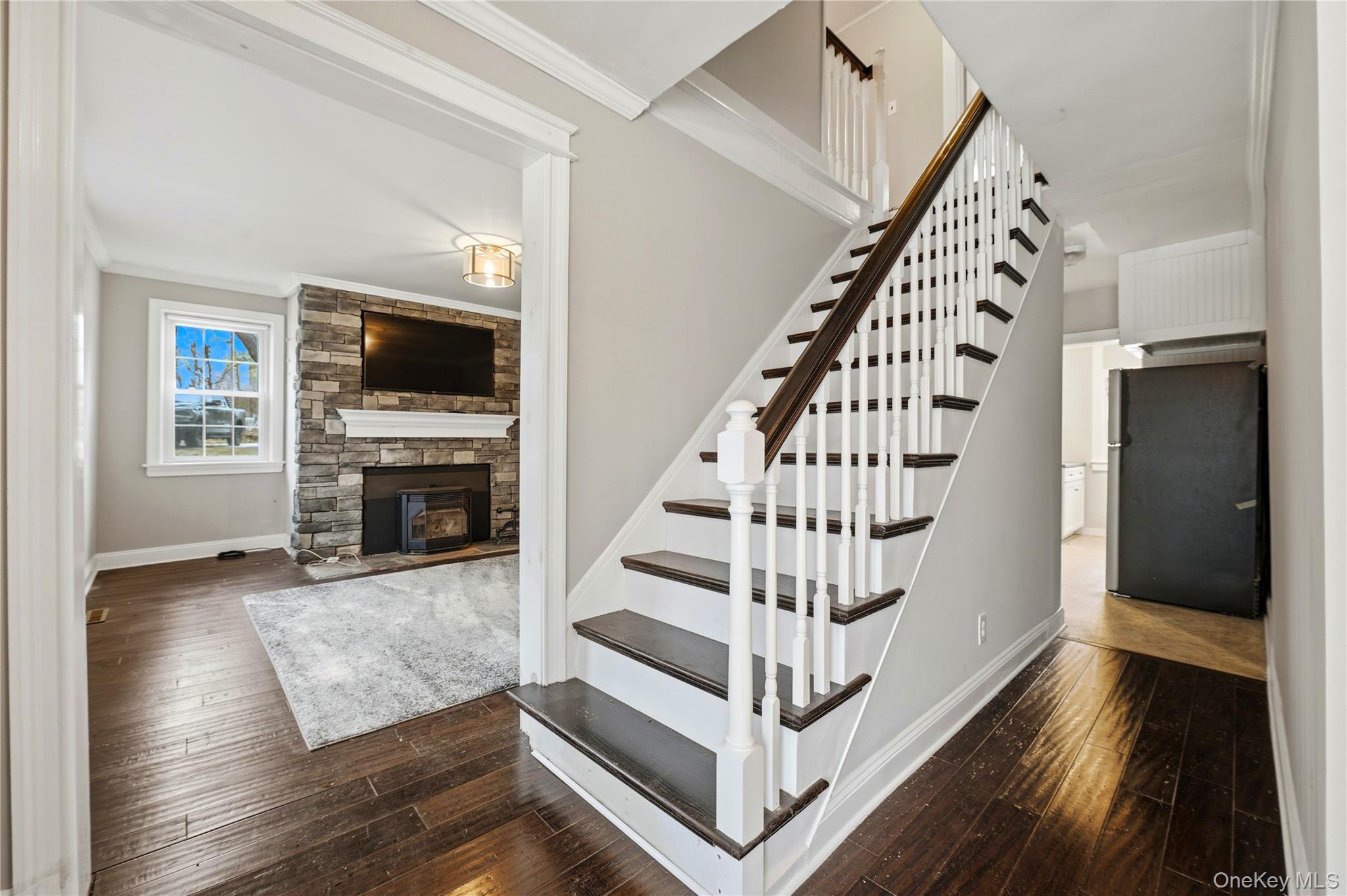 293 Highway 94 Warwick, NY 10990 - Photo 4 of 20 Staircase with wood-type flooring, crown molding, and a stone fireplace