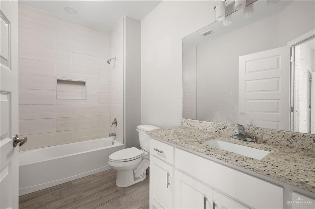 1804 Stauffer Street Weslaco, TX 78596 - Photo 11 of 17 a bathroom with a granite countertop sink a toilet and shower