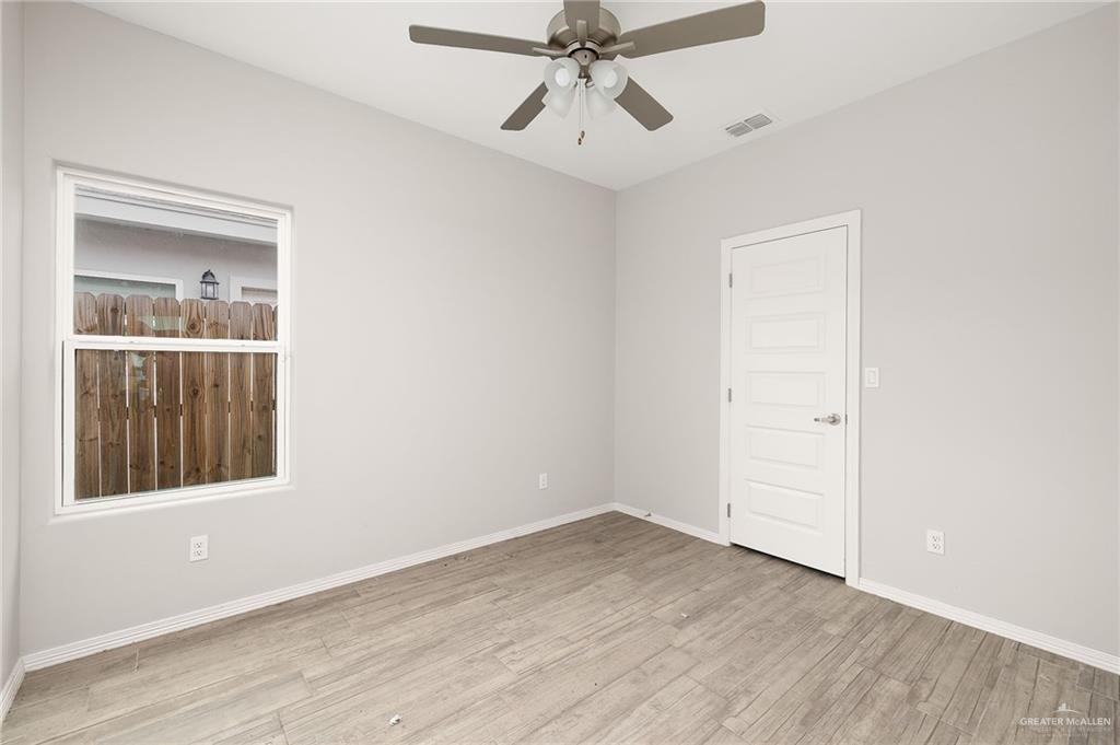 1804 Stauffer Street Weslaco, TX 78596 - Photo 12 of 17 a view of an empty room with a window and wooden floor