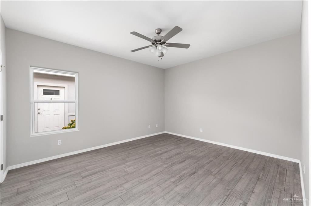 1804 Stauffer Street Weslaco, TX 78596 - Photo 15 of 23 an empty room with wooden floor windows and fan