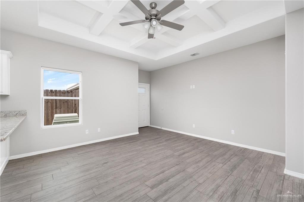 1804 Stauffer Street Weslaco, TX 78596 - Photo 4 of 23 an empty room with wooden floor chandelier fan and windows