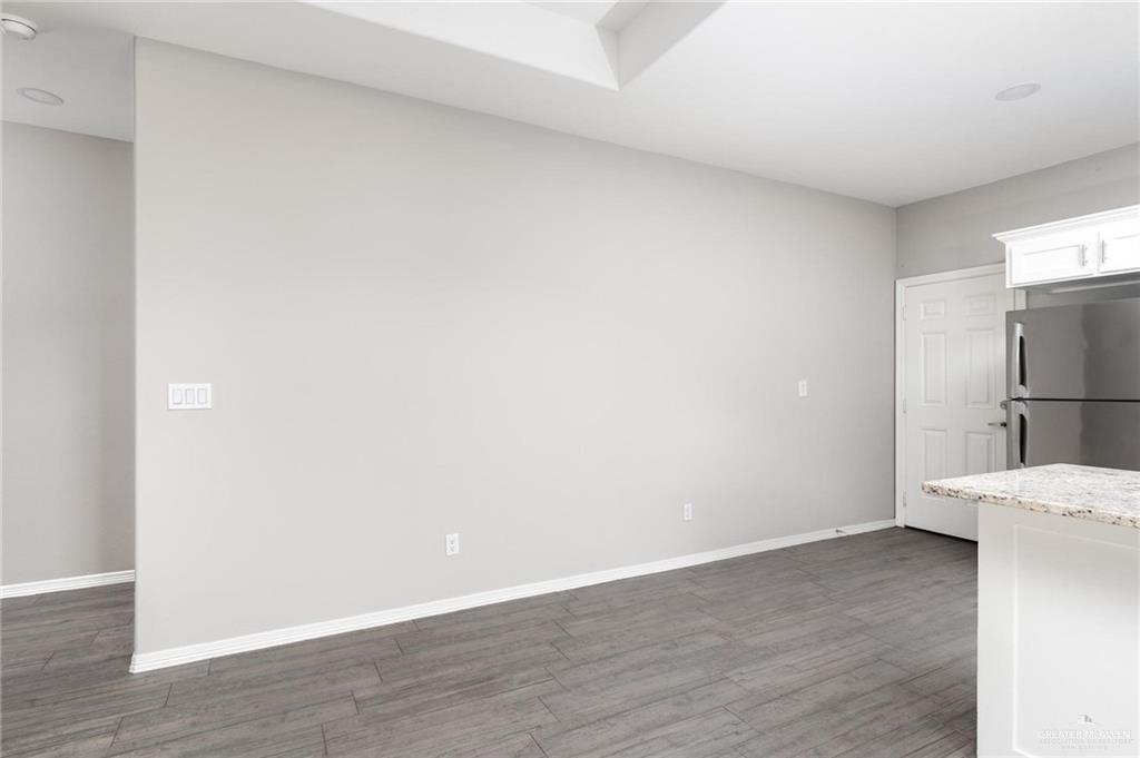 1804 Stauffer Street Weslaco, TX 78596 - Photo 6 of 23 a view of a kitchen with a refrigerator and wooden floor