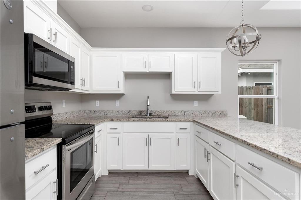 1804 Stauffer Street Weslaco, TX 78596 - Photo 7 of 23 a kitchen with stainless steel appliances granite countertop a sink and a stove