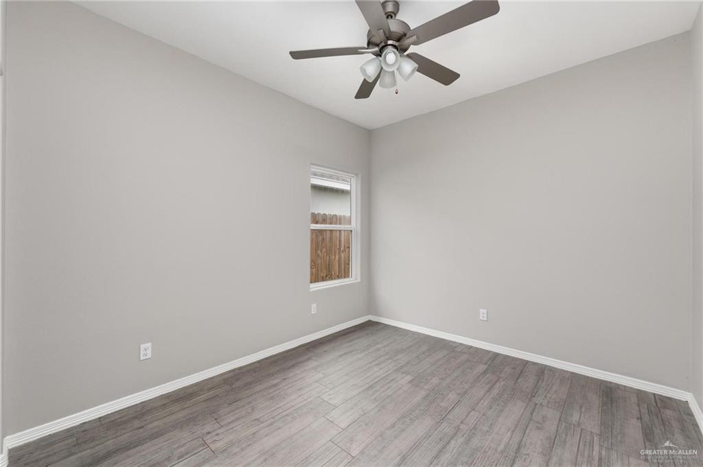 1804 Stauffer Street Weslaco, TX 78596 - Photo 9 of 23 wooden floor in an empty room with a window