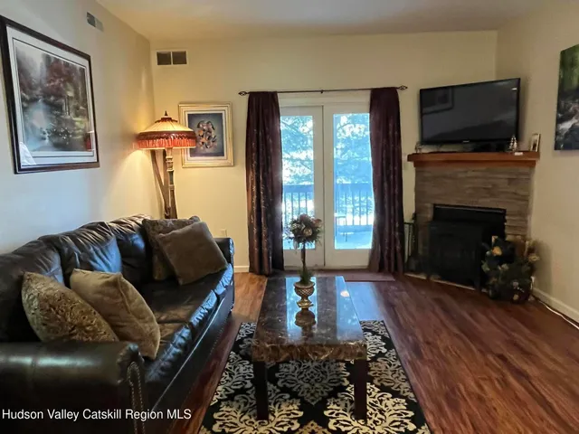 a living room with furniture a flat screen tv and a fireplace