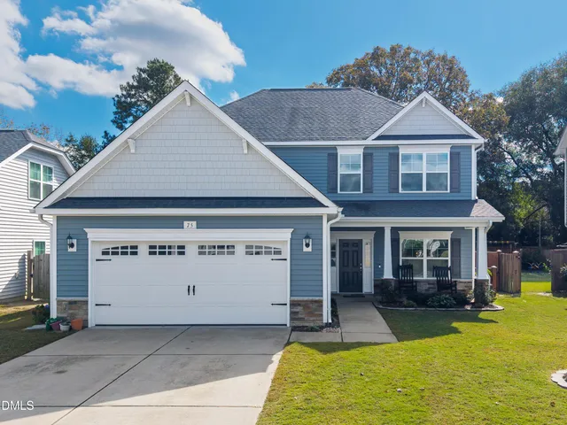 a front view of a house with a yard outdoor seating and garage