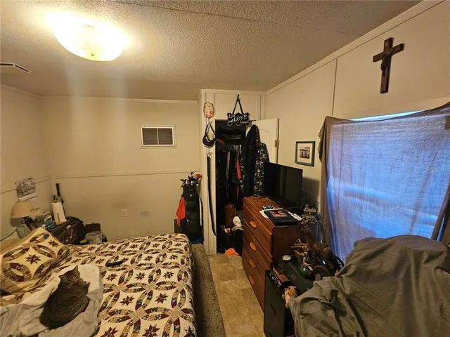 a bedroom with bed and a mirror