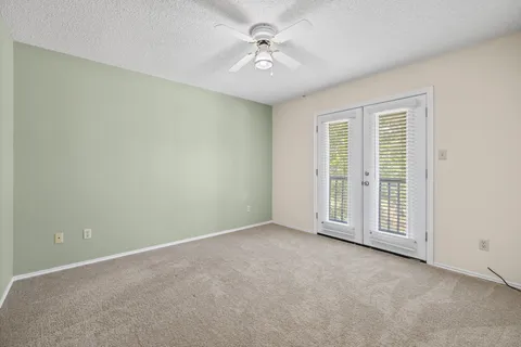 an empty room with a ceiling fan and a window