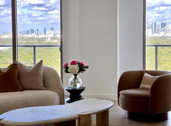 a living room with furniture flowerpot and a flat screen tv
