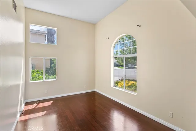 a view of a room with wooden floor fan and windows