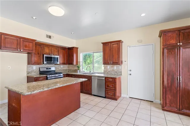 a view of a kitchen with kitchen island a sink wooden floor and glass doors