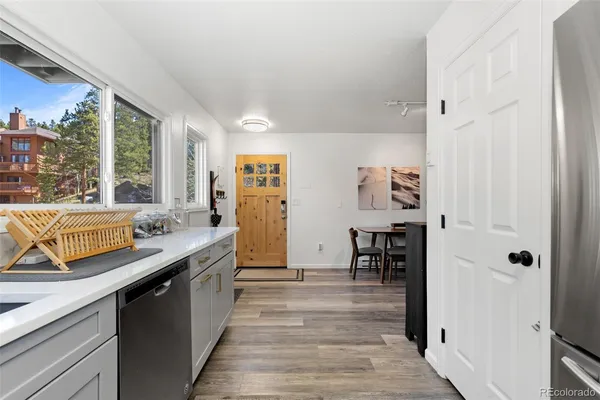 a kitchen with stainless steel appliances granite countertop a sink and wooden floors