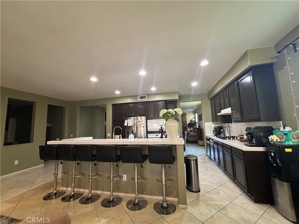 11571 Trailrun Court Riverside, CA 92505 - Photo 9 of 18 a kitchen with stainless steel appliances kitchen island granite countertop a sink and cabinets