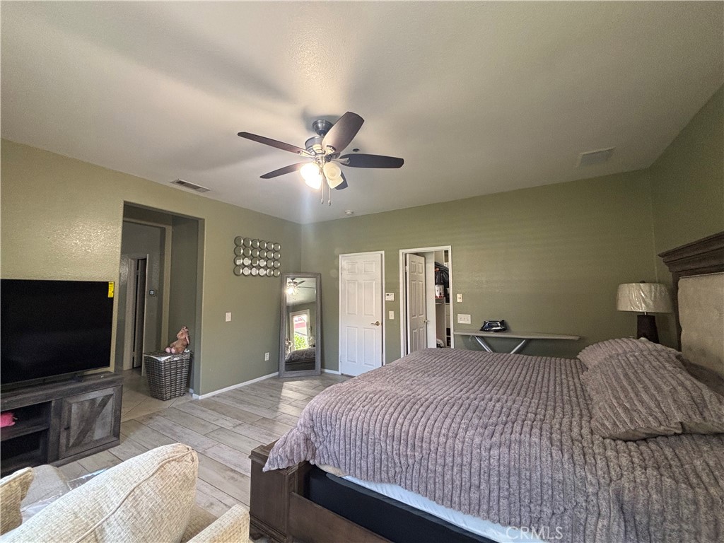 11571 Trailrun Court Riverside, CA 92505 - Photo 10 of 18 a bedroom with a bed and a flat screen tv