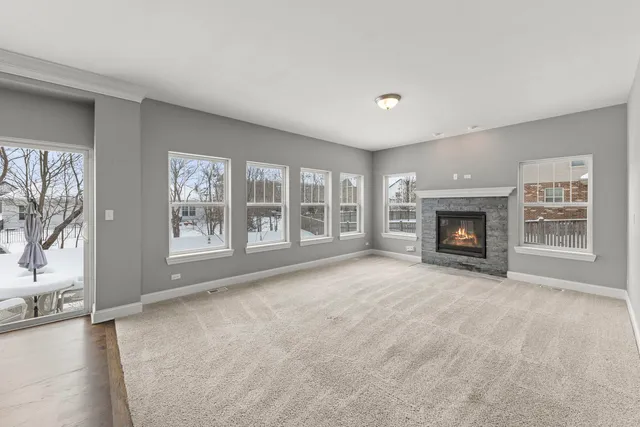 a view of an empty room with a fireplace and a window