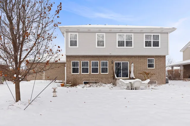a front view of a house with a yard covered in snow