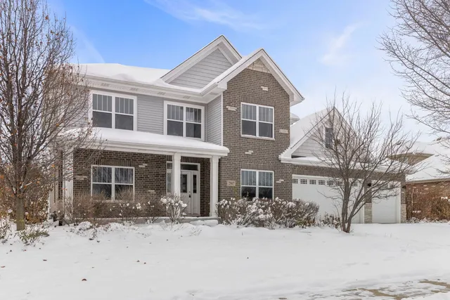 a front view of a house with a yard covered in snow